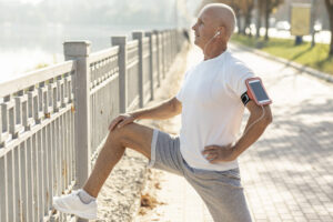 Elder man runner-resting beside fence