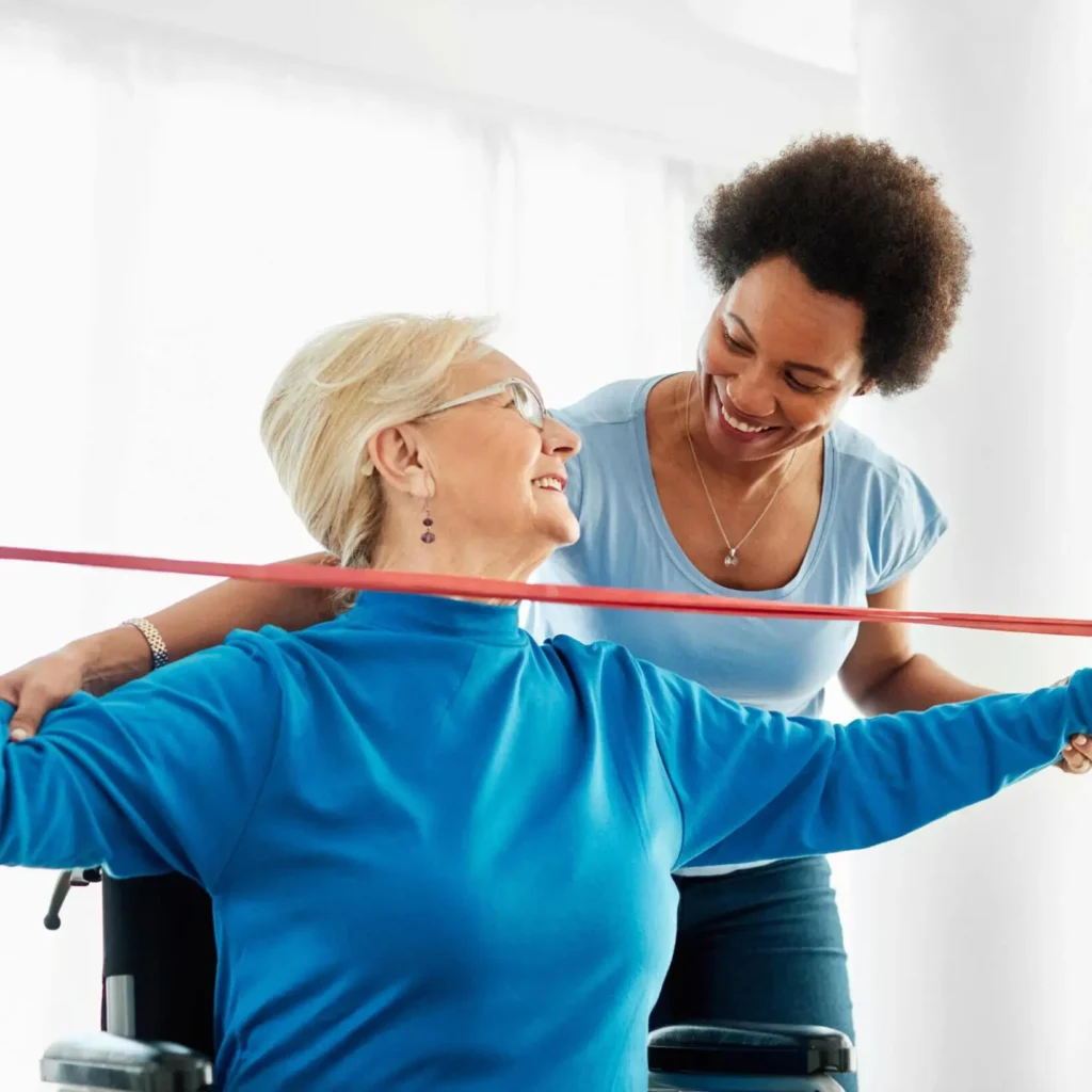 Physiotherapist guiding a senior patient with resistance band exercises for shoulder strength